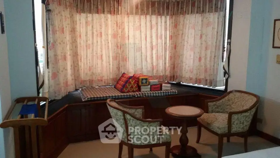 Charming living room with cozy seating and a window nook, perfect for relaxation.
