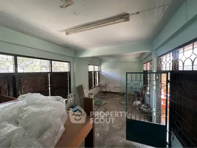 Spacious room with potential for renovation, featuring large windows and ample natural light.