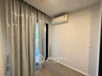 Cozy bedroom with air conditioning and elegant curtains, perfect for a comfortable living space.