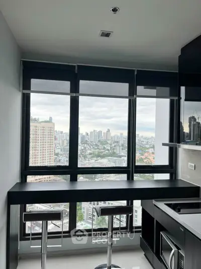 Modern kitchen with stunning city view and sleek black countertops.