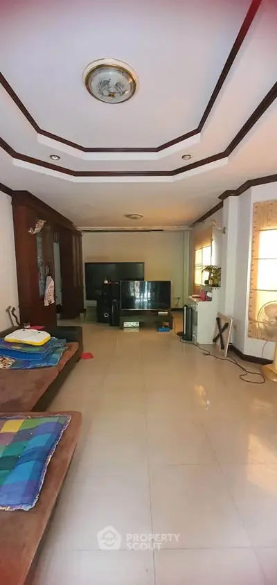 Spacious living room with modern decor and entertainment center, ideal for family gatherings.