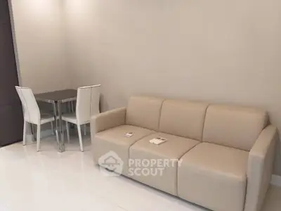 Modern living room with beige sofa and sleek dining table in minimalist design.