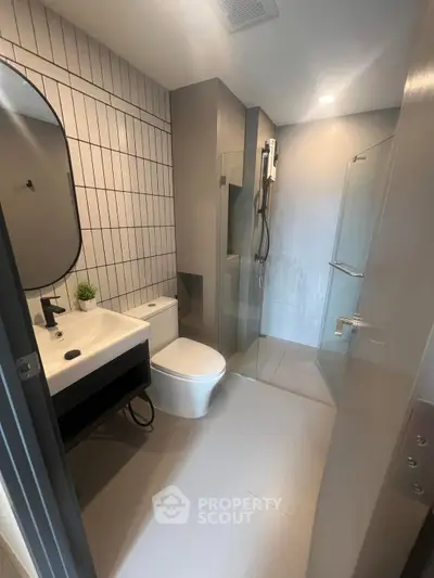 Modern bathroom with sleek design, featuring a glass shower and stylish fixtures.