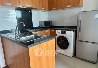 Modern kitchen with wooden cabinets, granite countertops, and built-in appliances.