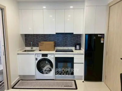 Modern kitchen with sleek appliances and stylish backsplash in a compact layout.