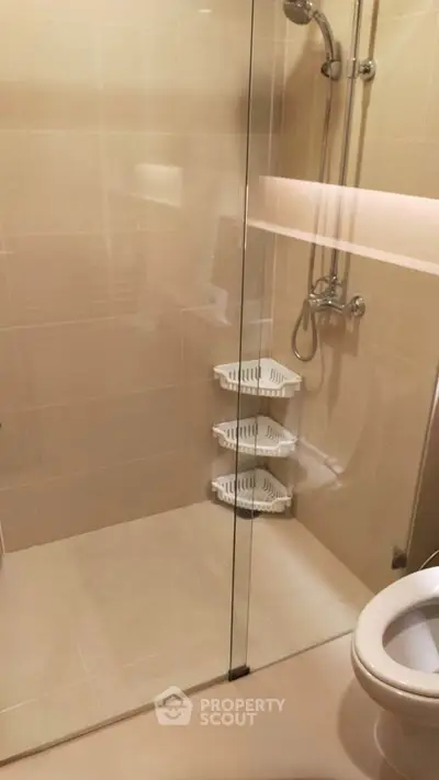 Modern bathroom with glass shower enclosure and sleek fixtures.