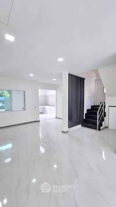Spacious modern living room with sleek staircase and marble flooring