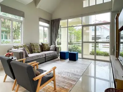 Spacious living room with modern decor and large windows offering garden views.