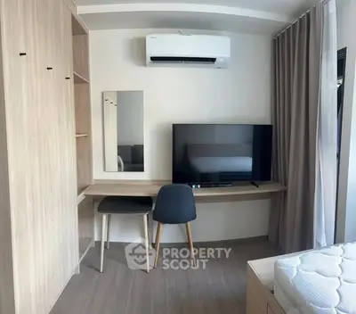 Modern bedroom with built-in wardrobe, desk, and wall-mounted air conditioner.