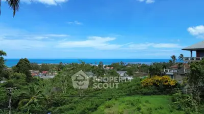 Stunning ocean view from a lush green hillside property, perfect for serene living.