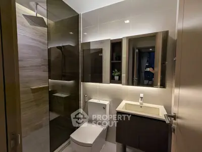 Modern bathroom with sleek design, featuring a glass shower enclosure and stylish vanity.