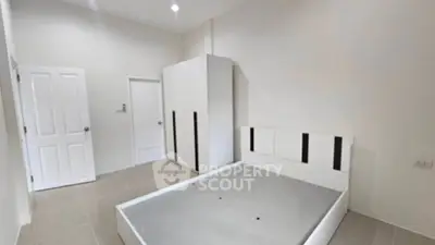 Spacious bedroom with modern minimalist design and ample storage space.