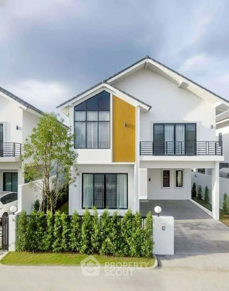 Modern two-story house with large windows and sleek design in a suburban neighborhood.