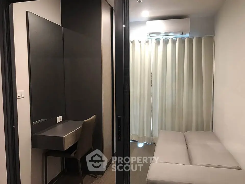 Modern apartment with cozy living area and study nook, featuring sleek furniture and natural light.
