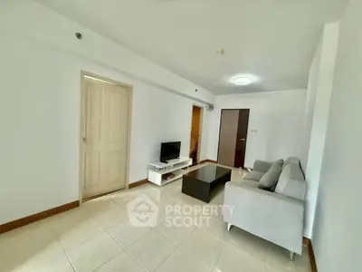 Spacious living room with modern sofa and TV setup, perfect for relaxation and entertainment.