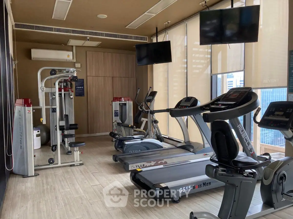 Modern gym with state-of-the-art equipment and city view, perfect for fitness enthusiasts in luxury real estate.