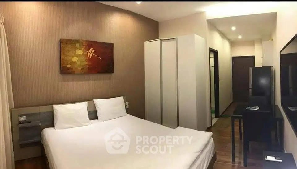 Modern bedroom with stylish decor and ample storage in a cozy apartment.