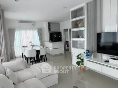 Modern open-layout living room with sleek furniture and integrated kitchen area.