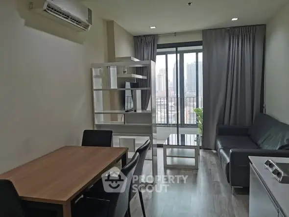 Modern living room with city view, featuring sleek furniture and large windows.