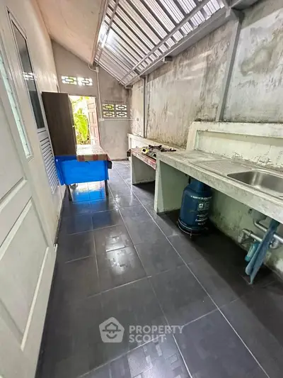 Spacious outdoor kitchen with gas stove and sink, perfect for culinary enthusiasts.