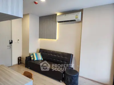 Modern living room with sleek black sofa and air conditioning unit