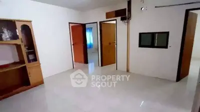 Spacious interior with tiled flooring and wooden doors, ideal for customization.
