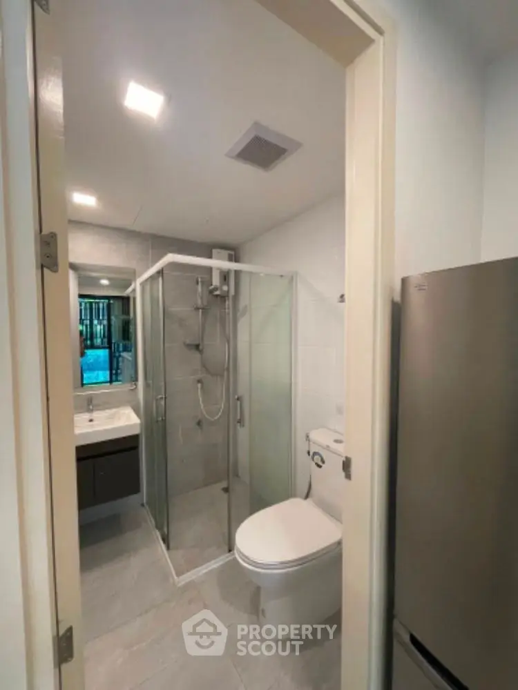 Modern bathroom with glass shower and sleek fixtures in a contemporary home.