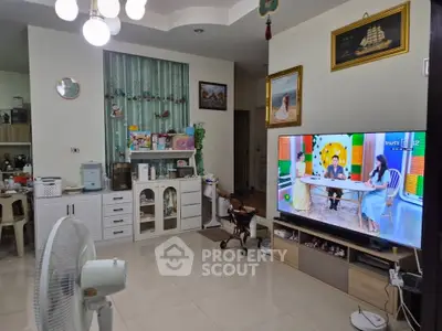 Spacious living room with modern decor and large TV, perfect for family gatherings.