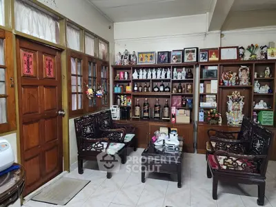 Charming living room with traditional wooden furniture and decorative shelves.