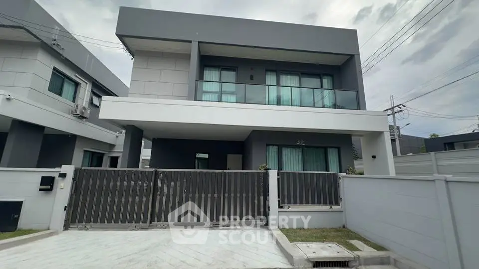 Modern two-story house with sleek design and spacious driveway in a suburban neighborhood.