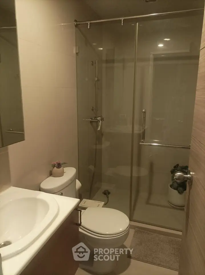 Modern bathroom with glass shower enclosure and sleek fixtures