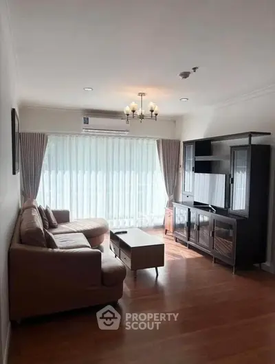 Spacious living room with elegant furniture and natural light in modern apartment.