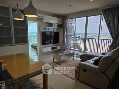 Spacious living room with modern decor and stunning balcony view in high-rise apartment.