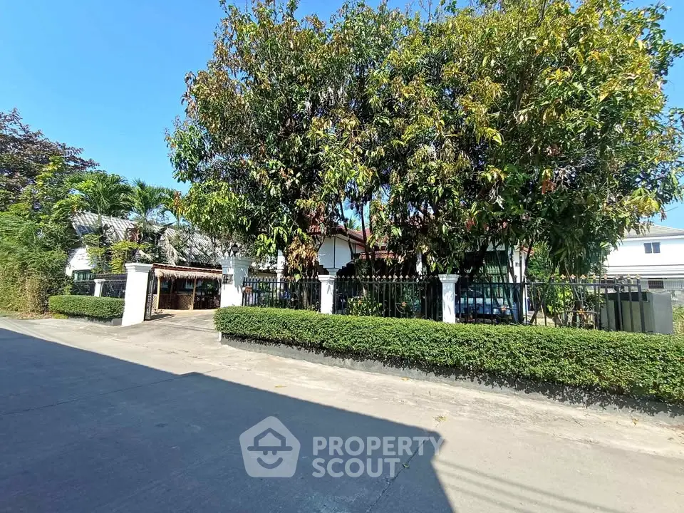 Charming residential property with lush greenery and secure fencing in a serene neighborhood.