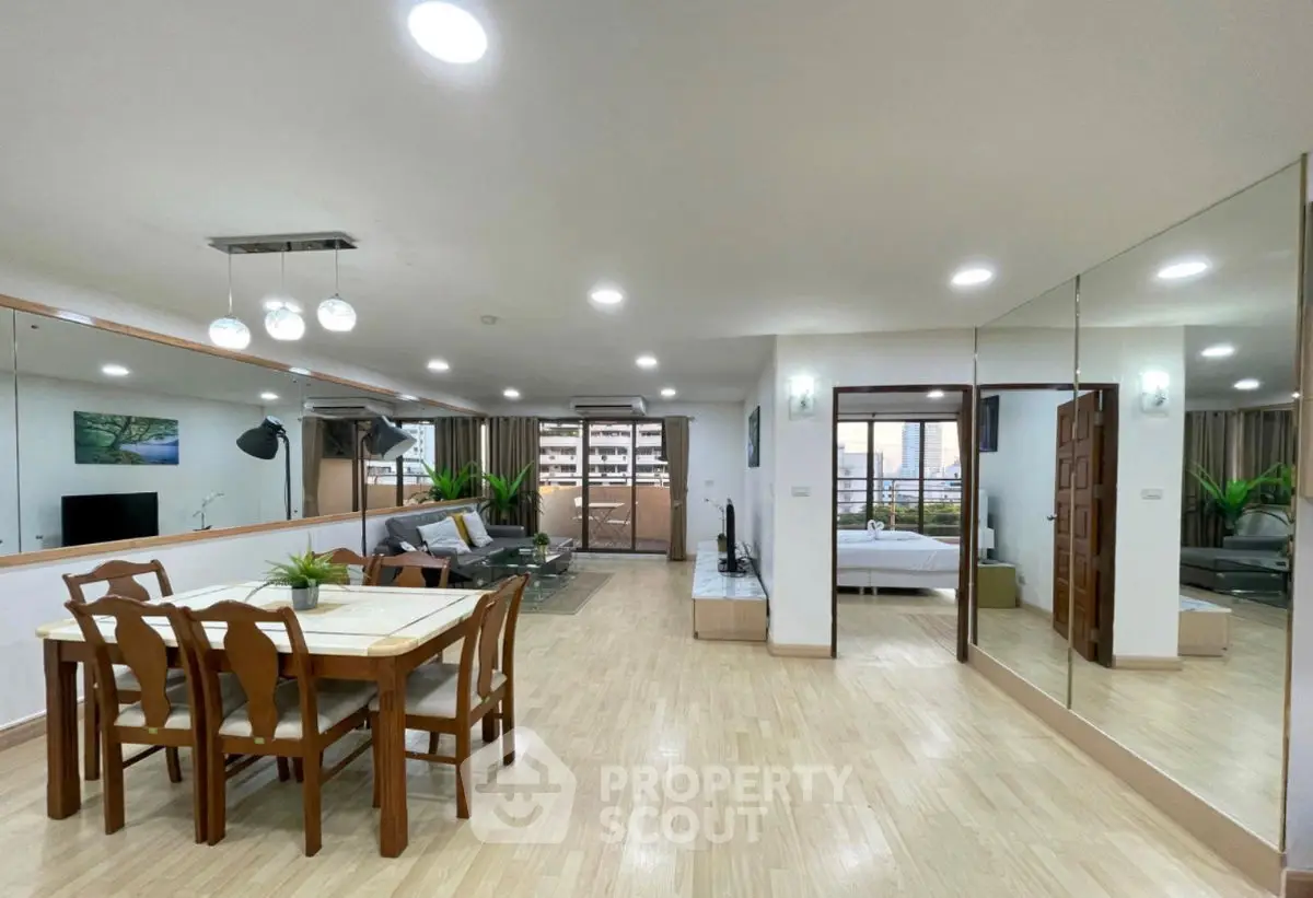 Spacious open-plan living and dining area with modern decor and large mirrors enhancing the space.
