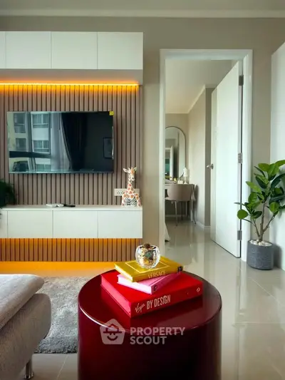 Modern living room with stylish decor and open view into adjacent room, featuring sleek furniture and ambient lighting.