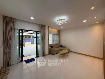 Spacious living room with modern decor and large sliding glass doors leading to outdoor area.