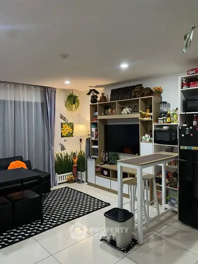 Modern living room with open kitchen, stylish decor, and cozy seating area.