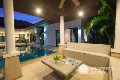 Luxurious villa with private pool and stylish outdoor seating area at dusk.