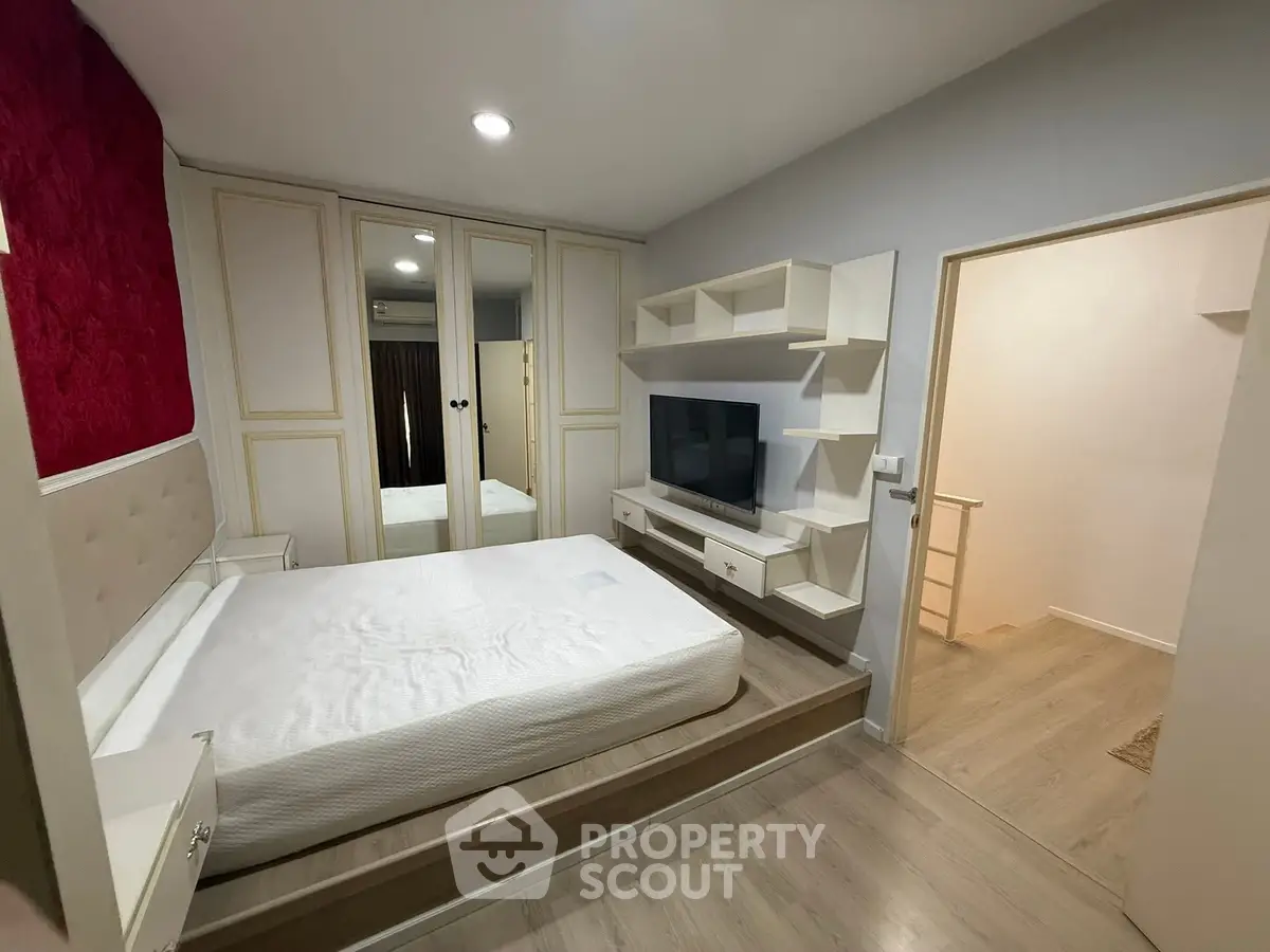 Modern bedroom with built-in storage and TV unit, featuring elegant design and cozy ambiance.