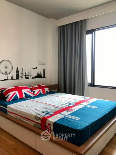 Modern bedroom with stylish decor and large window for natural light.