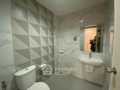 Modern bathroom with geometric tile design and sleek fixtures