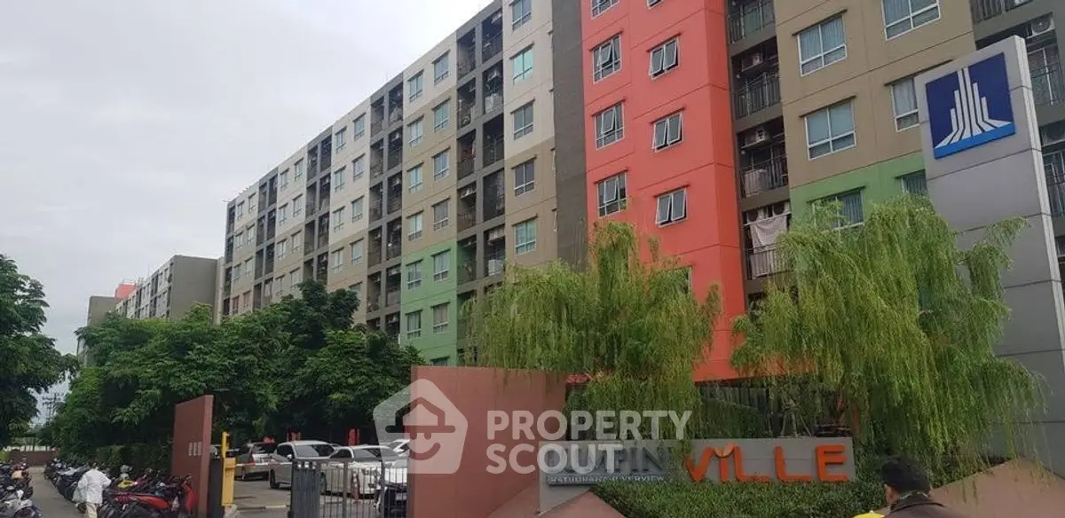 Modern apartment building exterior with colorful facade and lush greenery.
