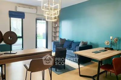 Modern living room with stylish furniture and blue accent wall, featuring a cozy seating area and contemporary lighting.