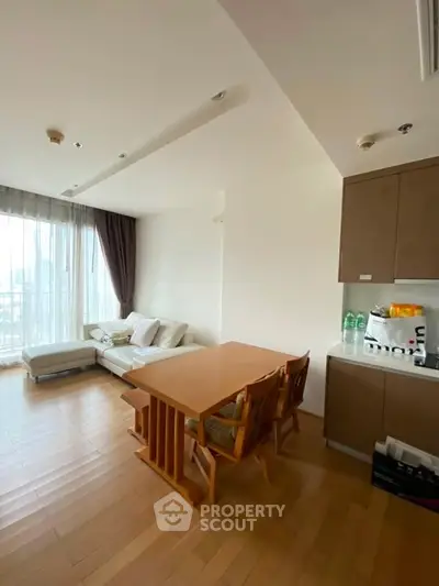 Spacious living room with natural light and modern furniture in a stylish apartment.