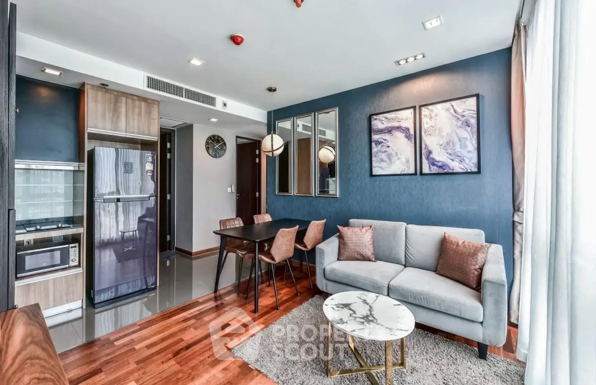 Modern living room with stylish decor, open kitchen, and cozy seating area in a contemporary apartment.