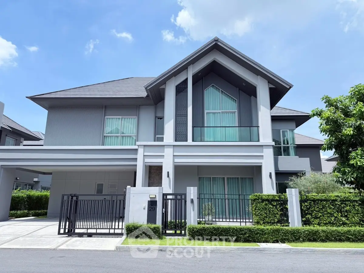 Stunning modern two-story house with sleek design and lush greenery, perfect for luxurious living.
