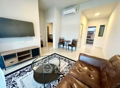 Modern living room with leather sofa, wall-mounted TV, and stylish decor