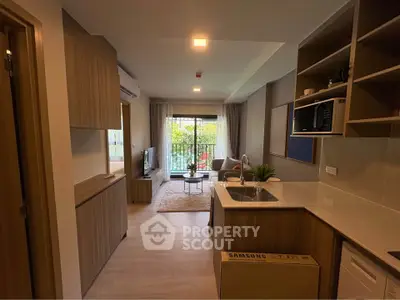 Modern open-layout kitchen and living room with balcony view in stylish apartment.
