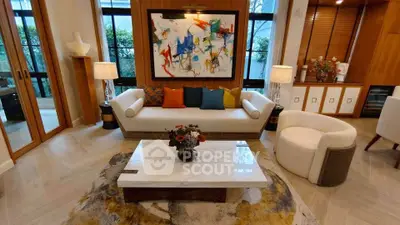 Luxurious living room with modern art, elegant furniture, and large windows for natural light.